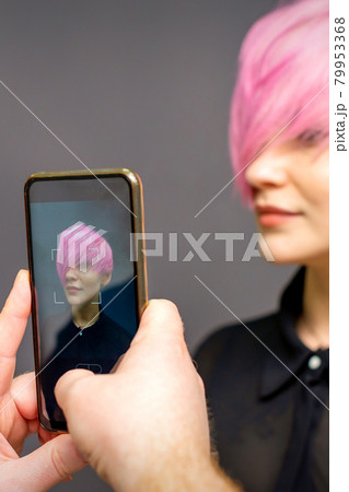 Man hairdresser's hands taking picture on smartphone of her client short pink hairstyle. Man hairdresser's hands taking picture on smartphone of her client short pink hairstyle. 79953368