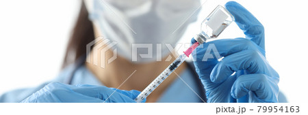 Doctor drawing medicine into syringe from vial closeup Doctor drawing medicine into syringe from vial closeup 79954163