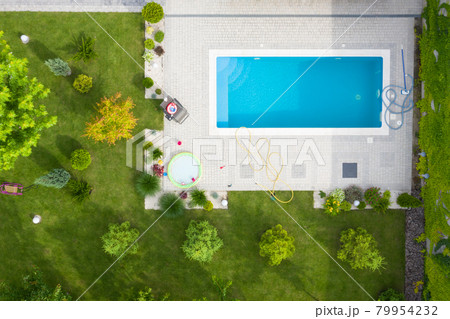 Aerial shot of green lawn and garden with a swimming pool in the courtyard. 79954232