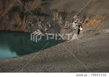 Young man and girl are walking next to the lake. Couple in love spend time forever together Young man and girl are walking next to the lake. Couple in love spend time forever together 79955156
