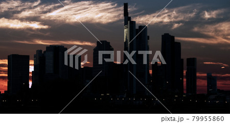 Dark skyline of a big city with skyscrapers in front of a dramatic sky with veil clouds at sunset 79955860