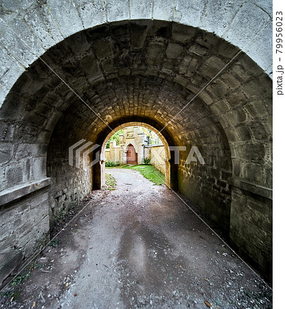 Dark passageway of roughly hewn stones with a round arch Dark passageway of roughly hewn stones with a round arch 79956023