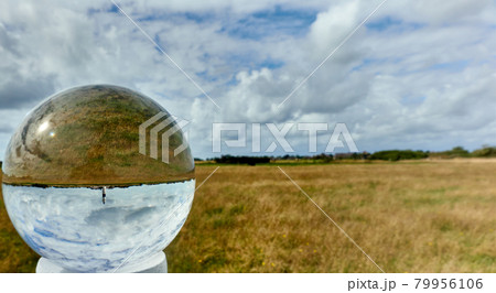 Crystal ball with the flat landscape of the North Sea island Sylt with a lighthouse Crystal ball with the flat landscape of the North Sea island Sylt with a lighthouse 79956106