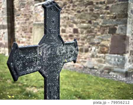 Medieval cast-iron cross with the wall of a stone church with background Medieval cast-iron cross with the wall of a stone church with background 79956212