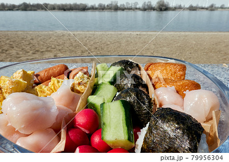 homemade japanese rice-ball on a sunny day at a pond 79956304