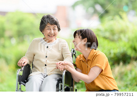 シニア女性 若い女性 新緑 介護 笑顔 車椅子 シニア女性 若い女性 新緑 介護 笑顔 車椅子 79957211