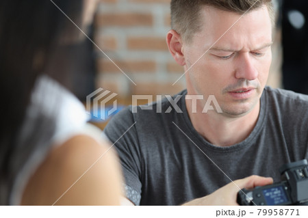 Male photographer is looking at camera screen with concentration Male photographer is looking at camera screen with concentration 79958771