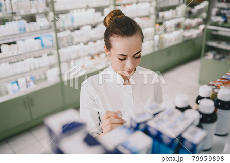 Woman pharmacist checking medicine in pharmacy 79959898