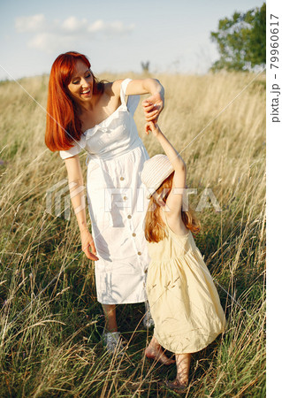 Mother with daughter playing in a summer field 79960617