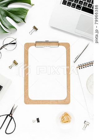 Home office workspace mockup with laptop, tropical leaves Monstera, clipboard, notebook and accessories on white background. Flat lay, top view 79966386