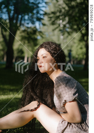 Young beautiful asian female sitting on the grass in a park 79969028