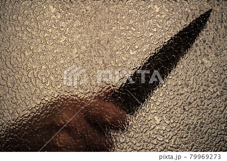 Knife in hand. Aggressive tin attack. Hacking attempt. The criminal behind the glass Knife in hand. Aggressive tin attack. Hacking attempt. The criminal behind the glass 79969273
