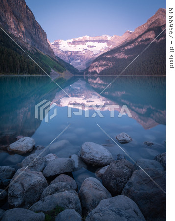 Portrait shot of beautiful alpine lake reflecting its surroundings, shot during sunrise at Lake Louise, Banff National Park, Canada 79969939