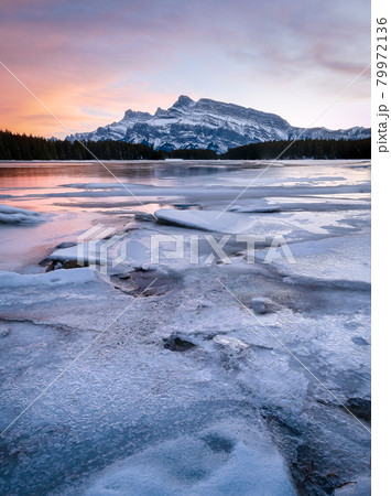Colorful sunset on frozen lake with isolated mountain in background, shot during sunset at Two Jack Lake, Banff National Park, Alberta, Canada 79972136