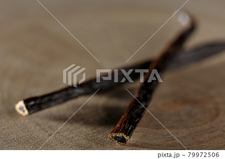 木材の上に置かれたバニラビーンズの写真素材