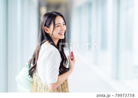 スマホを持つ大学生の女の子 79973758