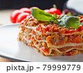 Extra close up view to piece of lasagna with basil 79999779