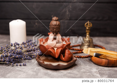 Aromatherapy and spa. Buddha figurine with incense smoke. Religious Aromatherapy and spa. Buddha figurine with incense smoke. Religious 80031764