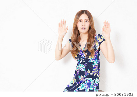 白い壁の前で、聞き耳を立てる、青いワンピースを着た若い女性 白い壁の前で、聞き耳を立てる、青いワンピースを着た若い女性 80031902