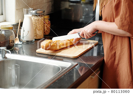 Woman Cutting Fresh Baguette Woman Cutting Fresh Baguette 80113060