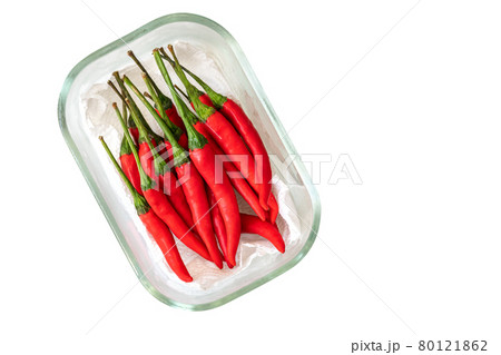 Top view red chilli or Jinda chilli of Thailand. Fresh red chilli in small glass container, supported by kitchen towel paper, isolated image on white background. Top view red chilli or Jinda chilli of Thailand. Fresh red chilli in small glass container, supported by kitchen towel paper, isolated image on white background. 80121862