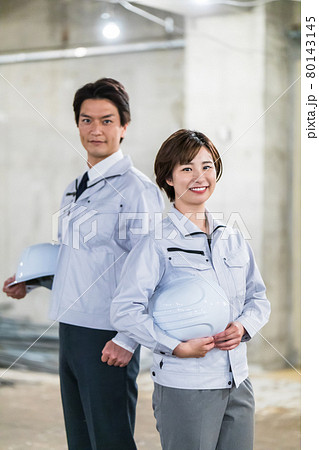 建築現場を見廻る工事関係者の男女2人 80143145