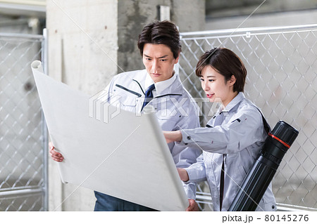 建築現場で図面を見ながら点検する男女 80145276