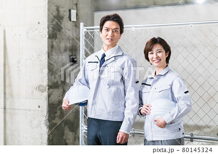 建築現場を見廻る工事関係者の男女2人 80145324