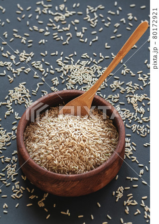 Brown rice in a wooden bowl with wooden or bamboo spoon 80172921