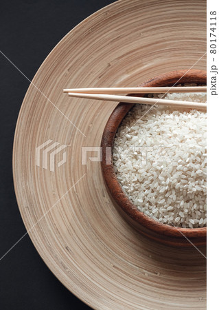 White rice in wooden bowl with wooden chopsticks White rice in wooden bowl with wooden chopsticks 80174118