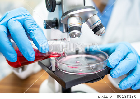 Asian scientist biochemist or microbiologist working research with a microscope in laboratory. For protect outbreak Coronavirus Covid19, bacteria and germs. Asian scientist biochemist or microbiologist working research with a microscope in laboratory. For protect outbreak Coronavirus Covid19, bacteria and germs. 80188130