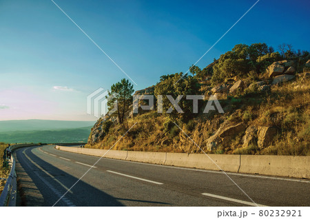 Country road on hilly landscape on sunset 80232921
