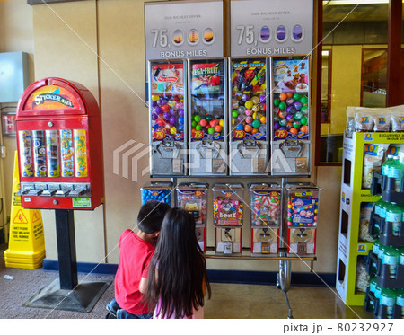 スーパーマーケットの片隅でカプセルトイをしている2人の子供 80232927