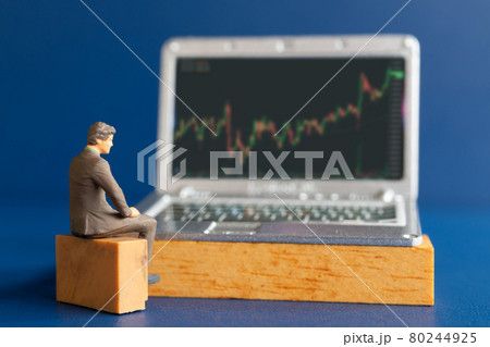 Miniature people, Business people and laptop featuring stock tickers 80244925