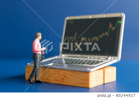 Miniature people, Business people and laptop featuring stock tickers 80244927