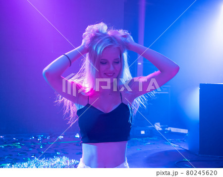 Portrait of beautiful DJ girl standing in the front of the decks. Party and holiday style.. 80245620