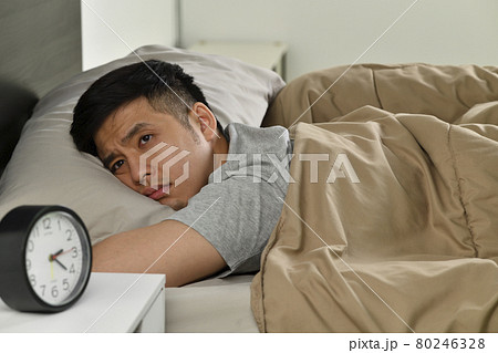 Depressed young Asian man lying in bed cannot sleep from insomnia 80246328