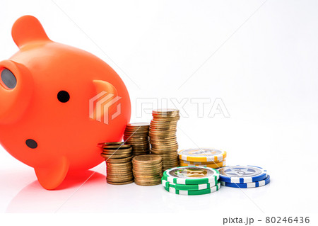 Piggy bank and money coins stack with casino chips on white background. Concept of gambling savings. 80246436