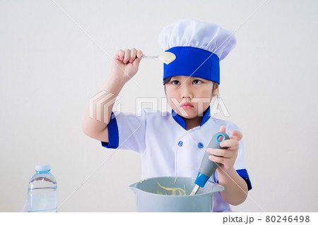 cute girls with amazing smile in clothes and chef cap. Cooking on kitchen cake. Kids make cookie at home, Children do dessert with eggs cute girls with amazing smile in clothes and chef cap. Cooking on kitchen cake. Kids make cookie at home, Children do dessert with eggs 80246498