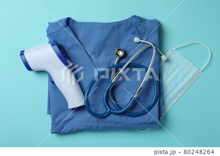 Medical tools and thermometer gun on blue background 80248264