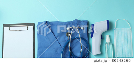 Medical tools and thermometer gun on blue background 80248266