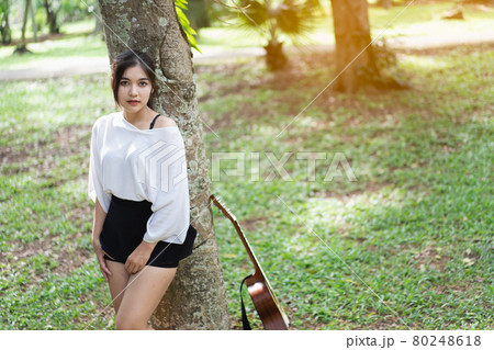 beautiful girl playing guitar at the garden 80248618