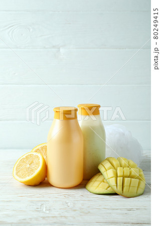Shower gels, mango and lemon on white wooden background Shower gels, mango and lemon on white wooden background 80249415