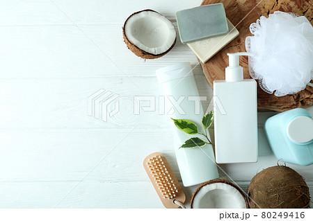Bath cosmetics and coconut on white wooden background 80249416