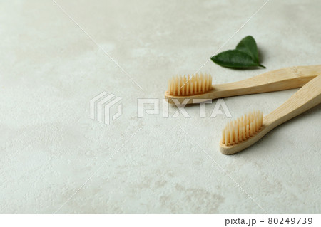 Eco friendly toothbrushes and leaves on white textured background 80249739