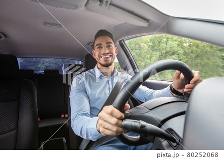 Smiling arab guy driving his car, shot from dashboard 80252068