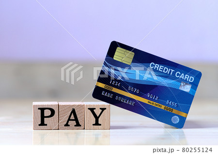 Mock up blue credit card and wood cube letter put on wooden table with spending via credit card Instead of cash concept 80255124