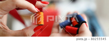Bright threads lie on a womans palm of seamstress Bright threads lie on a womans palm of seamstress 80255545