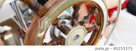 Wooden vintage steering wheel on a yacht close-up 80255575