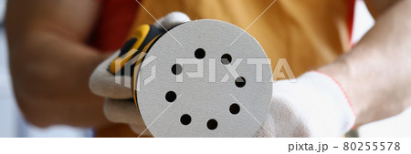 Male hands in gloves replaces spare part on sander 80255578